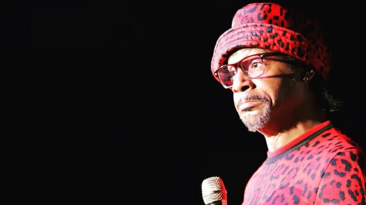 In a red and black spotted dress, Katt Williams confidently held a microphone.